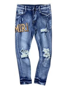AMIRI em denim azul com lavagem desgastada e aplicação de letras do logo.