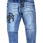 AMIRI em lavagem azul clara com detalhes desgastados e aplicação de patch com o logotipo em destaque na perna.