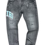 AMIRI Varsity Logo Repair Jeans em ganga preta desavivada com detalhes rasgados e o aplique do logótipo caraterístico em tom azul